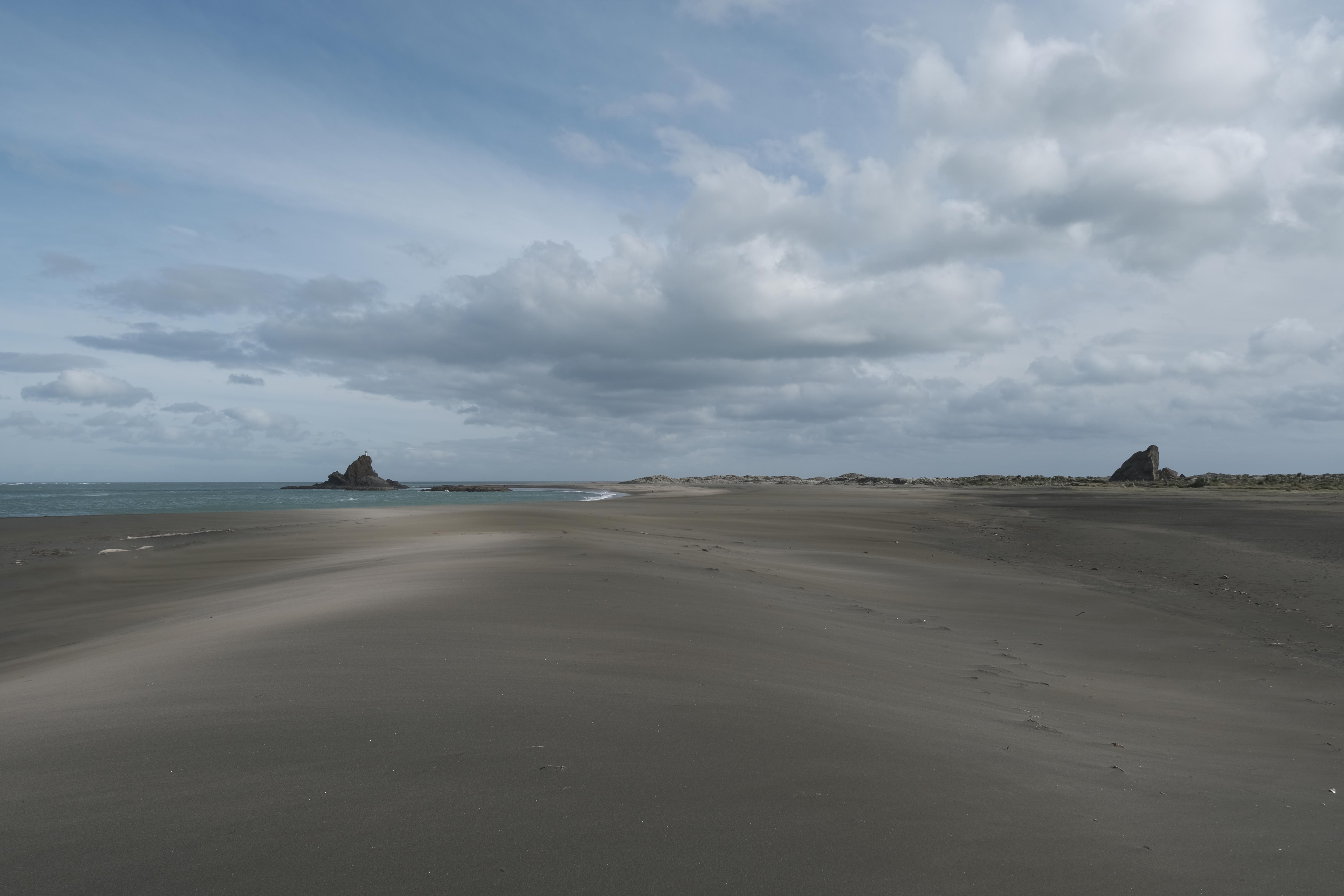 image of black sandy beach leading to the ocean